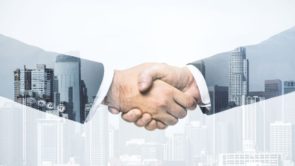Handshake of two businessmen on modern cityscape background, deal and trading concept. Multiexposure